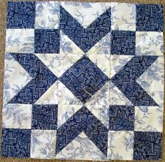 a blue and white patchwork quilt on the floor