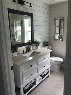 a bathroom with a sink, toilet and mirror