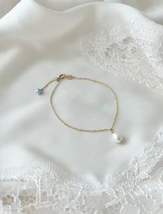 a bracelet with pearls on it laying on a white cloth