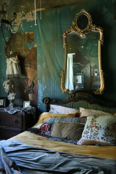 a bed sitting under a large mirror in a bedroom