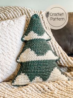 a crocheted christmas tree pillow sitting on top of a couch