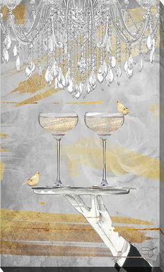 two champagne glasses on a tray under a chandelier