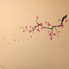 there is a bird sitting on the branch of a tree with pink flowers in it