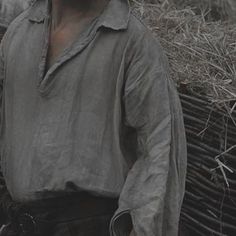 a man standing next to a pile of hay