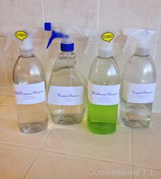 three bottles of water sitting on top of a tiled counter next to a tile wall