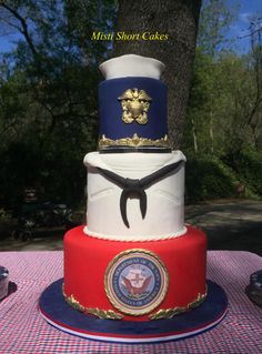 a three tiered cake with the seal of the u s navy on top and other decorations