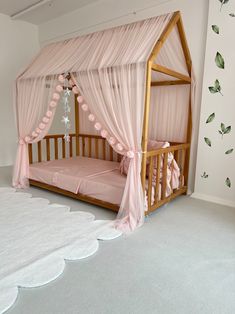 a pink canopy bed in a white room with curtains on the top and bottom half