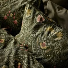 a close up view of a bed with floral designs on the sheets and pillow cases