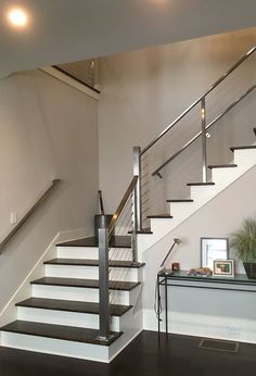 the stairs in this house are made of wood and metal, with glass railings