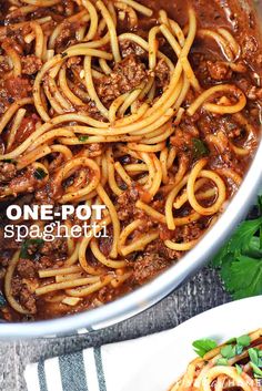 one pot spaghetti with meat sauce and parsley on the side, served in a white bowl