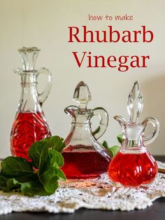 three glass bottles filled with liquid sitting on top of a table next to green leaves