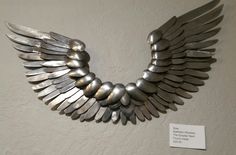 a metal sculpture with wings on the wall