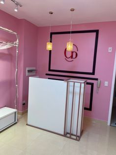 a room with pink walls and a white counter in the center, next to a bed