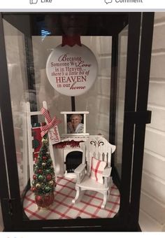 a display case with a christmas tree and other items in it on top of a checkered table cloth