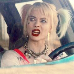 a woman with red lipstick sitting in a car