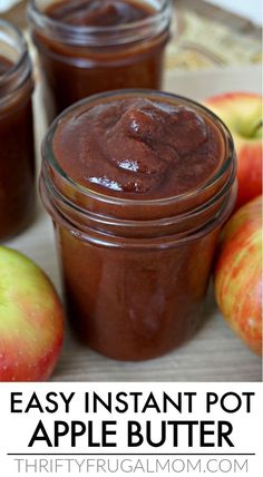 three jars filled with apple butter sitting on top of a table next to some apples