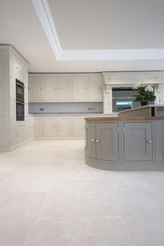 a large kitchen with white cabinets and an island