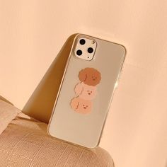 an iphone case with a poodle on it sitting next to a pillow and chair