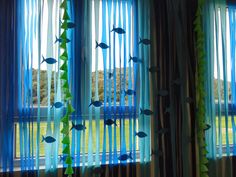 blue curtains with fish on them in front of a window