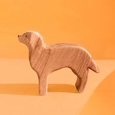 a wooden toy dog on an orange background