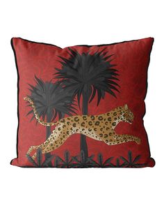 a pillow with a leopard and palm trees on it