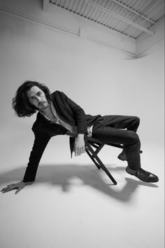 a black and white photo of a man sitting on a chair