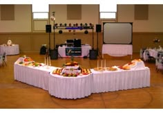 a banquet hall with tables covered in white tablecloths and food on top of them