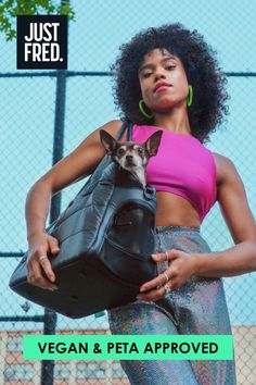 Vegan and PETA approved small and large dog carriers.  Image shows a stylish young woman holding the dog carrier with a dog peeking its head out of the top.  This destination tote limited edition has a built-in dog waste bag dispenser, zipped top and peekaboo window.  This bag is PETA approved. Shop now at Just Fred. Small Pet Carrier