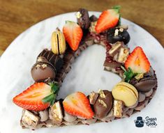 a white plate topped with a cake covered in chocolate and strawberries