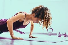 a woman is doing push ups on the floor