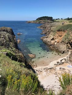 the beach is surrounded by rocky cliffs and clear water