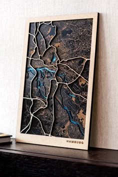 a wooden block with a map of hamburg on it's side next to a book