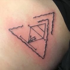 a triangle tattoo on the back of a woman's shoulder