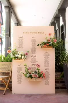 a seating chart with flowers in planters on the side of a white board that says find your seat