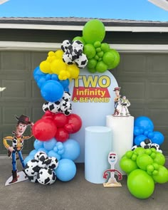 there are many balloons and toys on the ground near a sign that says two infinity and beyond