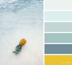 a pineapple sitting on top of a sandy beach next to the ocean with color swatches