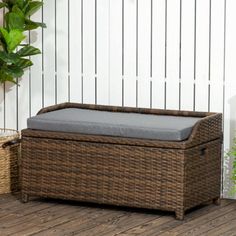 a wicker bench sitting on top of a wooden floor next to a potted plant