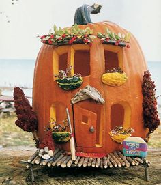 a pumpkin shaped house sitting on top of a tree stump