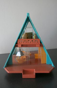 a doll house with a blue roof and orange trim on the bottom floor is shown