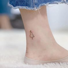 a small christmas tree tattoo on the ankle