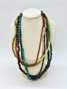 VTG Multi-Strand Beaded Necklace Brass Clasp Colorful Boho * 6 strand   * Antique brass tone clasp + hardware accents  * Earthy color palette   * Mixture of wood + plastic beads  * Length adjustable chain with lobster clasp  very good condition, metal accents are imperfect, slightly bent  no actual flaws!  measurements - approximate  measurements - approximate clasped length: SHORTEST STRAND: 9" -- LONGEST STRAND: 11.5" unclasped length: 19.6"  largest bead is about 0.25"  weight: 1.2 oz Multi Strand Beaded Necklace, Earthy Color Palette, Metal Accents, Canterbury, Plastic Beads, Colorful Boho, Metallic Accents, Multi Strand, Beaded Necklaces