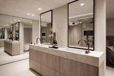 a bathroom with two sinks and mirrors on the wall