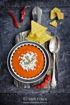 a bowl of tomato soup with tortilla chips on the side