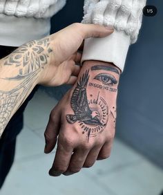 a person with a tattoo on their hand holding onto another persons arm and the other hand has an eagle tattooed on it