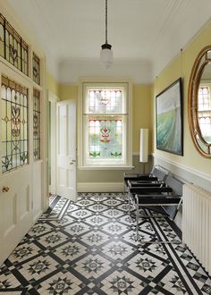 a hallway with stained glass windows and black and white flooring