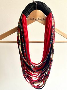 a multi - stranded necklace hangs on a wooden hanger