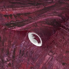 a white object sitting on top of a red marble floor next to a black and white wall