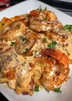 a white plate topped with shrimp and cheese covered in sauce