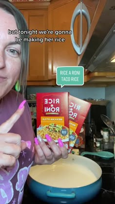 a woman holding up two boxes of rice in her hand and pointing at the camera