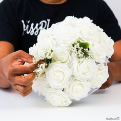 a person holding a bouquet of white roses